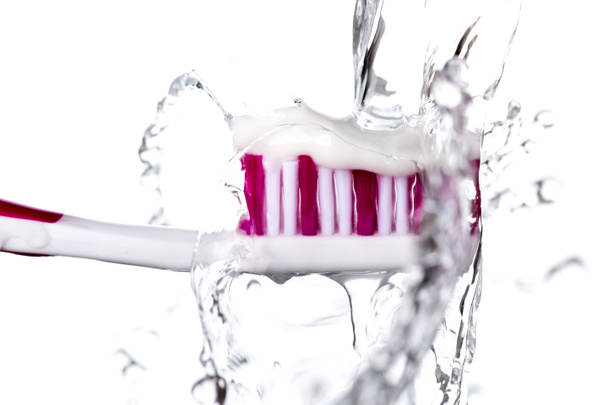 Cepillo de dientes con pasta de dientes bajo agua salpicada
 - Foto, Imagen