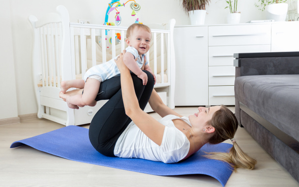 Beautiful mother practicing yoga with her baby boy - Foto, Imagen
