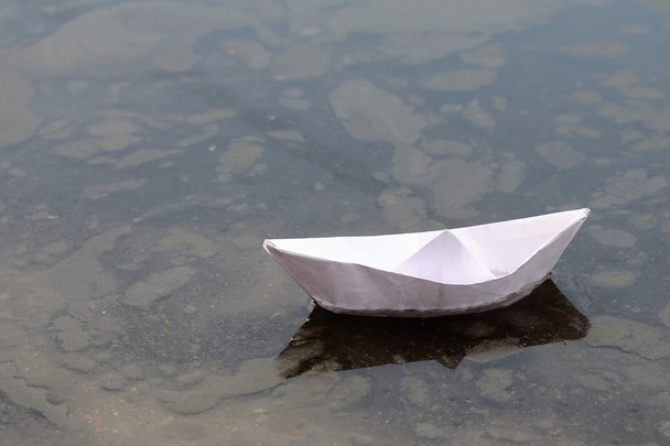 Boot opgebouwd uit het Witboek in een plas van vuil water - Foto, afbeelding