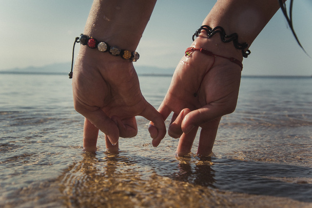 mãos de casal na praia
 - Foto, Imagem
