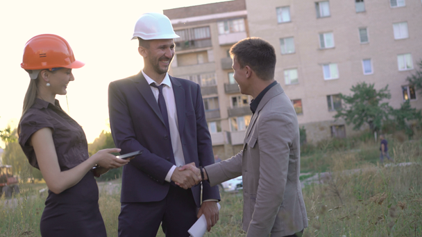 Business team meet up with client and shake hands on construction. 4K - Felvétel, videó