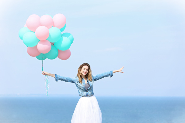 Nainen värikkäiden ilmapallojen kanssa
 - Valokuva, kuva
