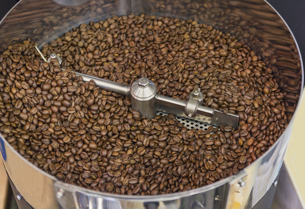 Coffee beans during the roasting process inside the hopper drum  - Foto, imagen