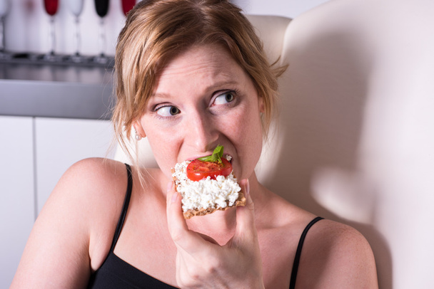 Piękna Blondynka kobieta jest jej chleb z serem i pomidorem  - Zdjęcie, obraz