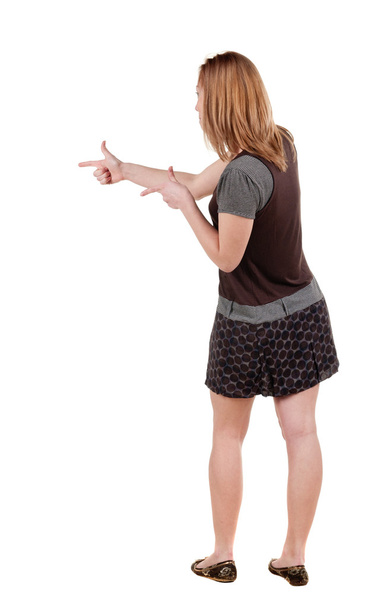 Back view of young blonde woman pointing at wall . - Foto, immagini