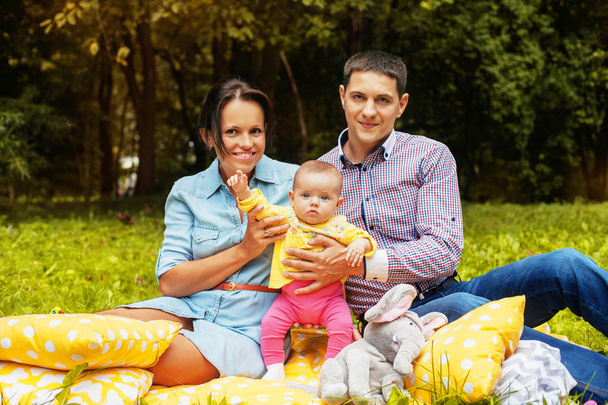 pais felizes no parque para um piquenique com o bebê. O conceito de família e amor
. - Foto, Imagem