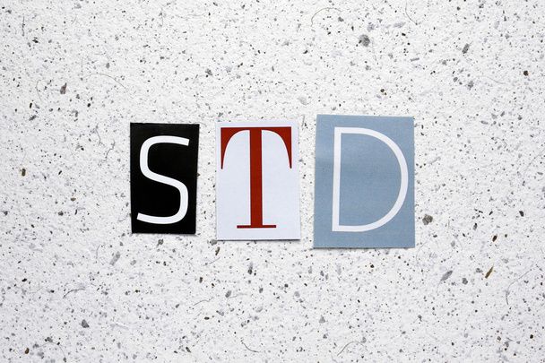 STD (seksualnie zakażenia przenoszone) skrót na wycięte z gazety na tekstury biały papier czerpany - Zdjęcie, obraz