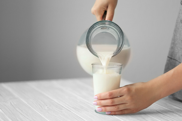 hand pouring milk - Foto, afbeelding