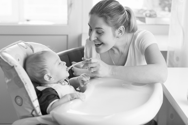 Ritratto in bianco e nero di madre sorridente che nutre il suo bambino in h
 - Foto, immagini