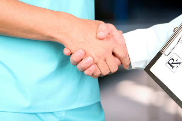 medical doctor  with a stethoscope around his neck shaking hand with colleague - Photo, Image
