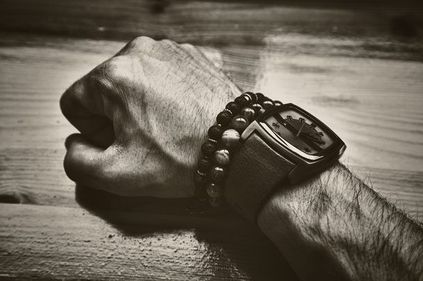 potente mano di uomini brutali con un orologio e bracciali decorativi. Foto in stile seppia
 - Foto, immagini