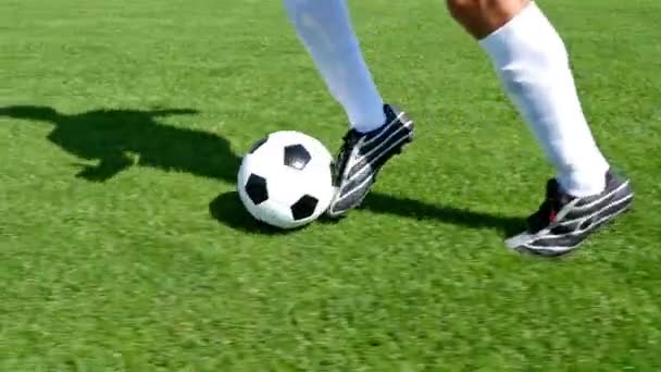 Voetballer leidt de bal op een voetbalveld, slow-motion - Video