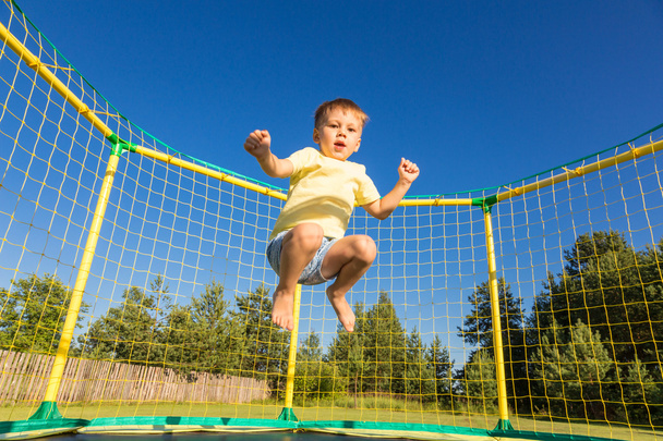 Kleine jongen op een trampoline - Foto, afbeelding