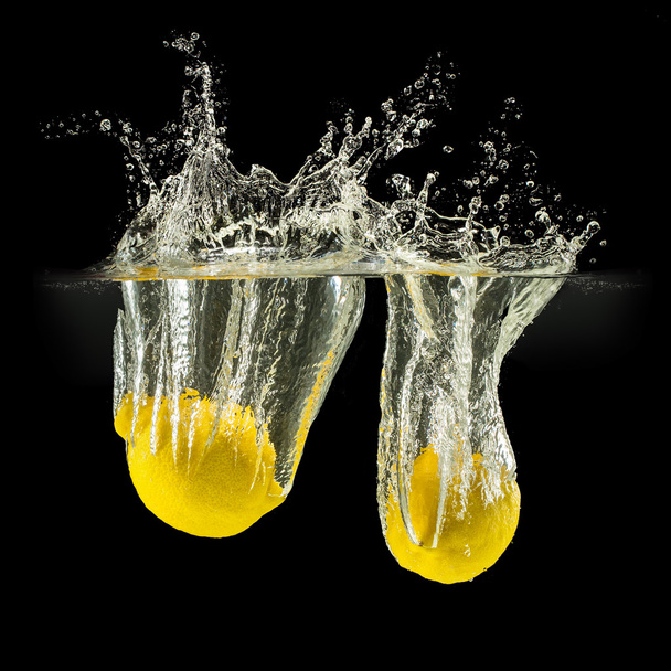 Group of fresh fruits falling in water with splash on black background - Photo, Image
