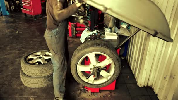 Mechanic balancing car wheel on an automated machine checking - Footage, Video