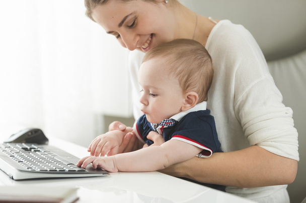 Mujer joven cuidando del bebé en la oficina
 - Foto, Imagen