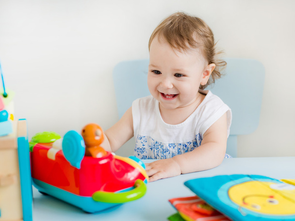 девочка играет с развивающей игрушкой в детской - Фото, изображение