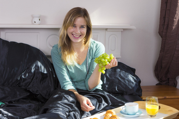 Chica desayunando en la cama
 - Foto, imagen