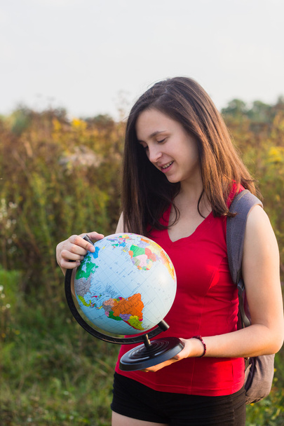 A girl with backback holding globe - Photo, image