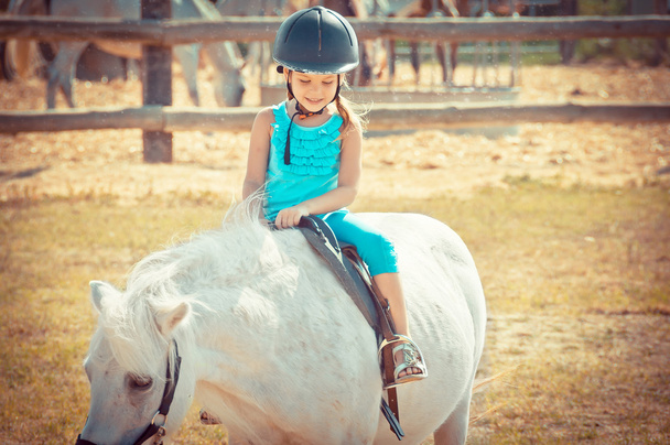 Una chica encantadora montada a caballo. Niño y objetivo. Niña montado un ho
 - Foto, imagen