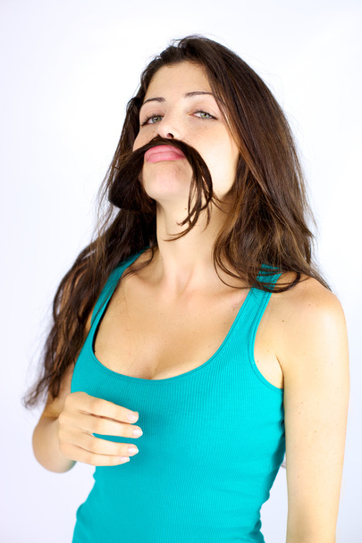 Beautiful woman making funny face with hair as moustache - Photo, image