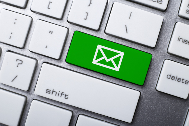 Концепции электронной почты и онлайн-общения, с символом электронной почты на клавиатуре
. - Фото, изображение