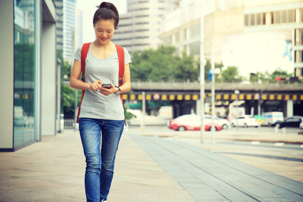 woman walking with smart phone - Zdjęcie, obraz