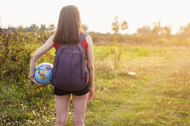 ein Mädchen mit Rückenlehne hält Globus - Foto, Bild