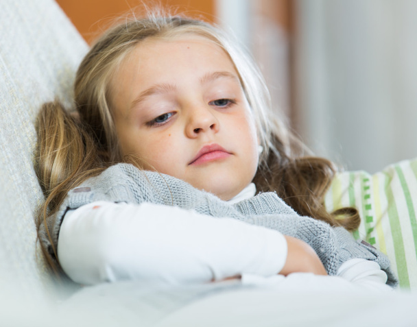 Miserable female child posing in couch - Photo, image