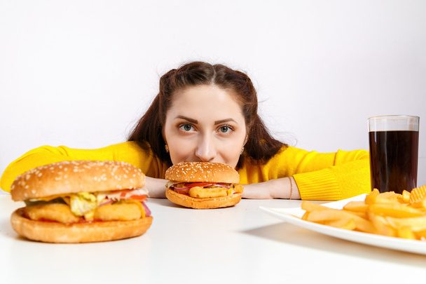 Girl bites off a huge hamburger. Unhealthy diets.  - Φωτογραφία, εικόνα