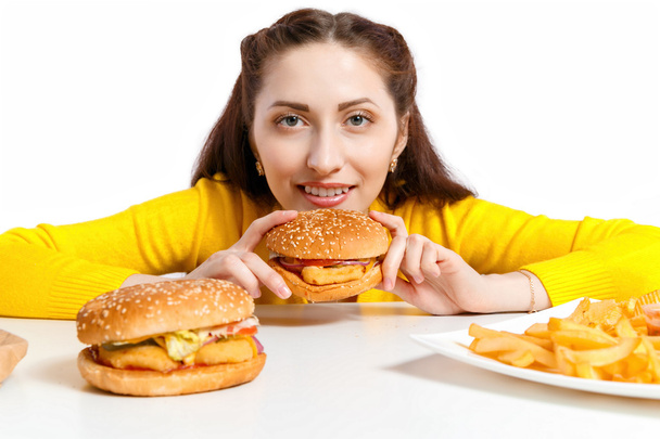 Girl bites off a huge hamburger. Unhealthy diets.  - Fotó, kép