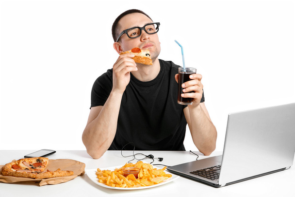 Man working at the computer and eating fast food. Unhealthy Life - Φωτογραφία, εικόνα