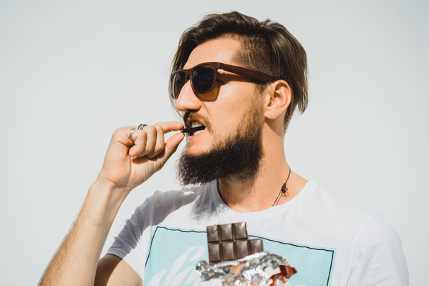 Happy bearded man eats chocolate - Photo, image