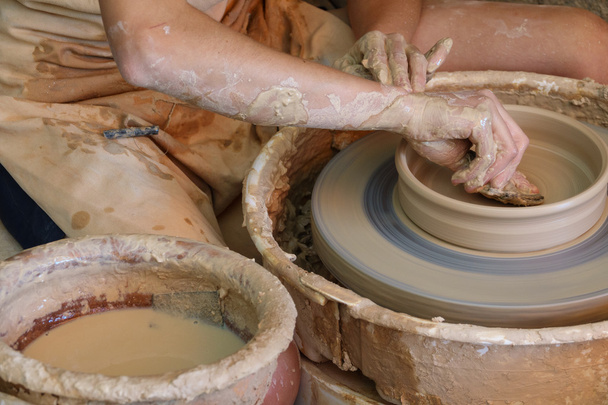 Vuile handen werken op aardewerk wiel - Foto, afbeelding