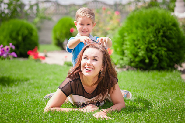 Mother and son having fun on the grass - 写真・画像