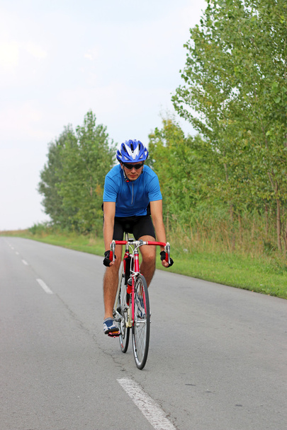 велосипедист-мужчина на велосипеде по дороге
 - Фото, изображение