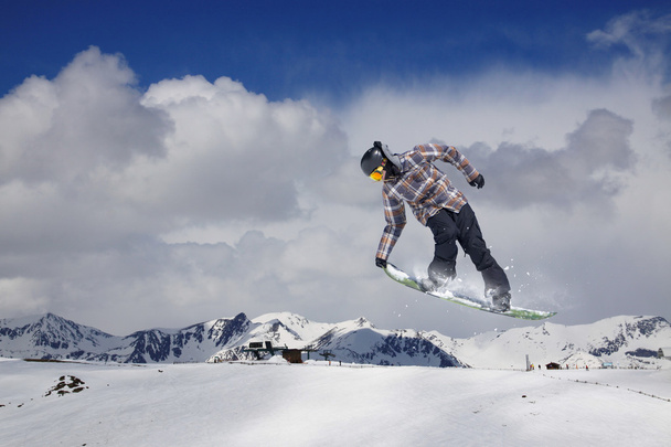 Lumilautailija hyppii lumisilla talvivuorilla
 - Valokuva, kuva