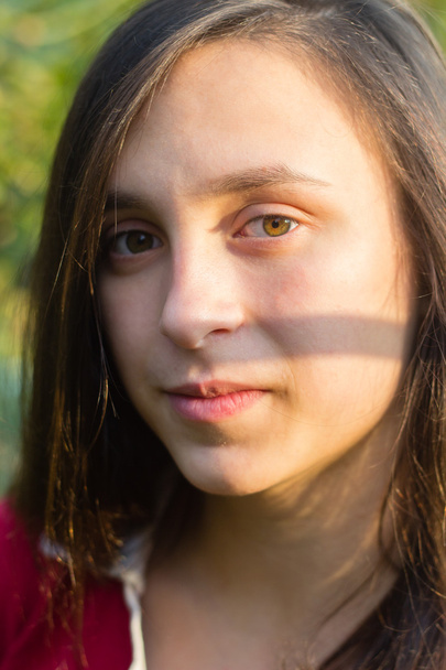 Portret van tienermeisje met donker haar in de buurt van boom - Foto, afbeelding