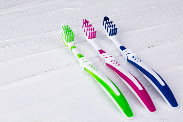 Brosses à dents sur fond blanc en bois
 - Photo, image