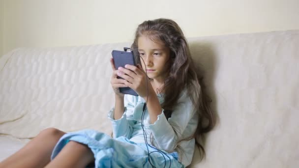 Girl child with a cell phone browses the Internet - Filmmaterial, Video