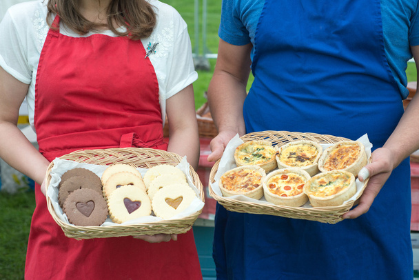 two people holding baskets of sweet and savoury pastries - Photo, Image