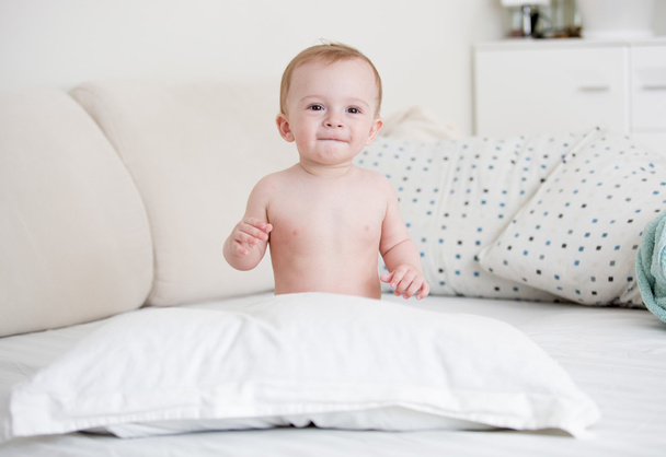 Bébé garçon nu assis sur le lit dans la chambre
 - Photo, image