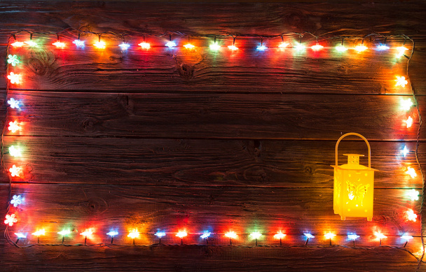 Ahşap arka plan üzerinde lambaların Noel çelenk. - Fotoğraf, Görsel