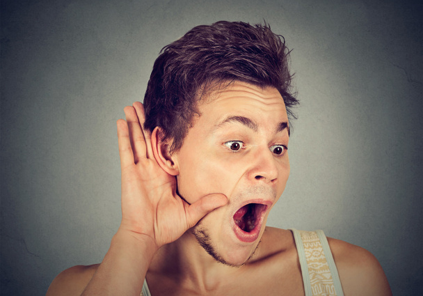 Verbaasd nieuwsgierige man hand naar oor gebaar zorgvuldig luisteren gossip - Foto, afbeelding