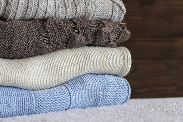 Stack of cozy knitted warm sweater on your home background . - Photo, Image