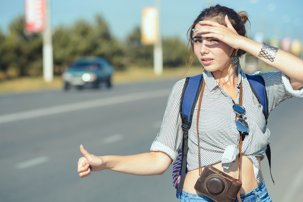 Travel woman hitchhiking. Beautiful young female hitchhiker - 写真・画像