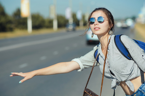 Travel woman hitchhiking. Beautiful young female hitchhiker - Photo, Image