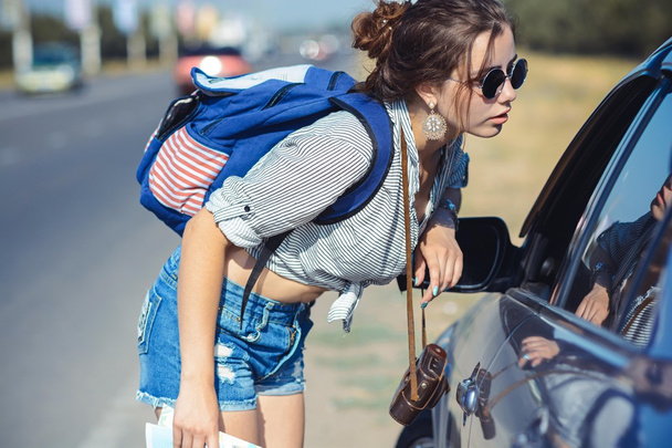 Young female hitchhiker asking a road to driver - Foto, Imagem