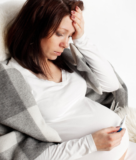 Mujer embarazada con un termómetro
 - Foto, imagen