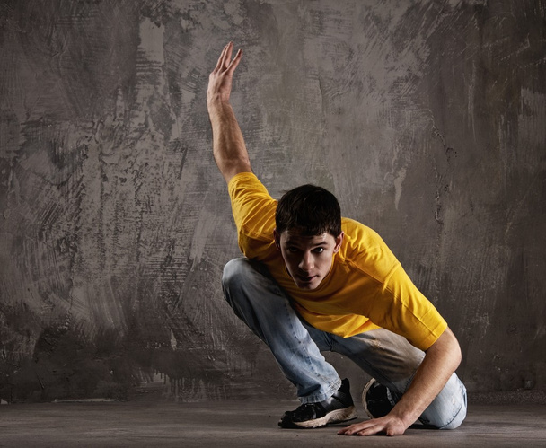 Young man dancing against grunge wall - Foto, immagini
